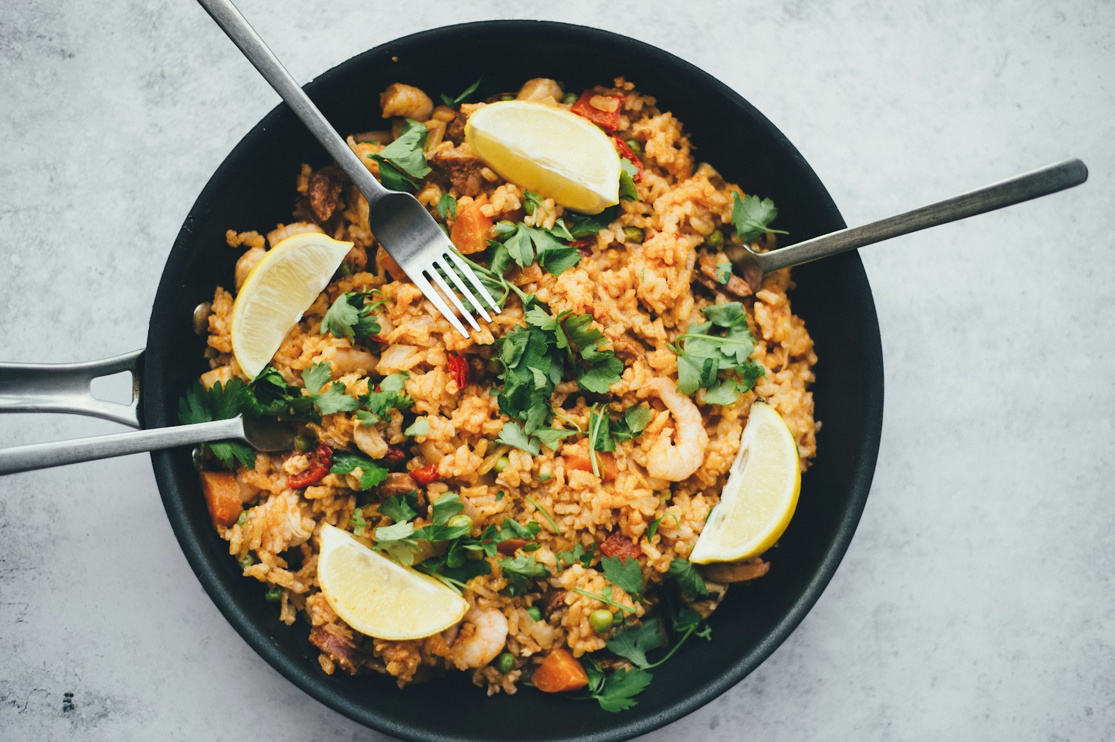 Sepiring nasi goreng rumahan dengan telur mata sapi dan pelengkap sayuran