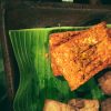 Tempe goreng crispy berwarna keemasan tersaji di piring sebagai camilan dan lauk rumahan