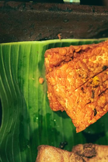 Tempe goreng crispy berwarna keemasan tersaji di piring sebagai camilan dan lauk rumahan